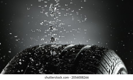 Car Tire With Splashing Water In Detail, Macro Photo, Weather Concept. Studio Photo, Free Space For Text.