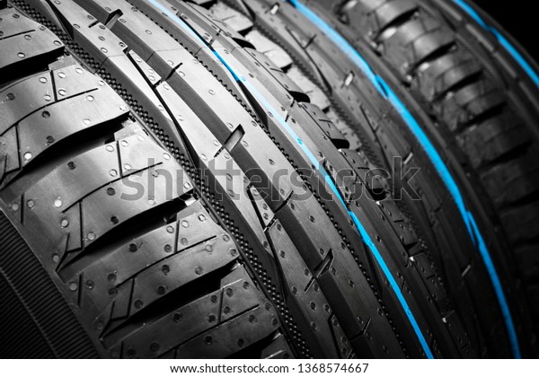 Car tire. Tire stack. Car tyre protector close up.\
Black rubber tire. Brand new car tires. Close up black tyre\
profile. Car tires in a row
