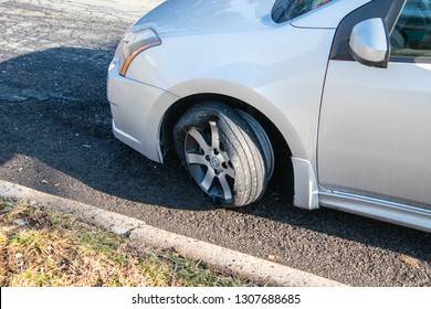 Car tire that has a blowout with rim and car damage. Tire is coming off of rim. Tire is on a car that is on an asphalt street - Shutterstock ID 1307688685