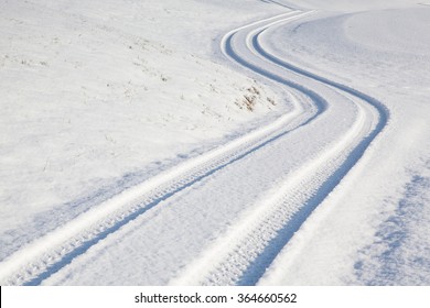 Car tire track on a empty winter road