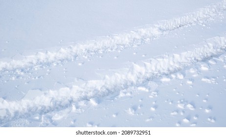 Car tire tracks in deep snow in winter. Snow desert and the tracks of the car in the snow. Traces of tires on snow. Car tire track on a empty winter road. - Powered by Shutterstock