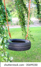 Car tire used as kids swing on trees in the garden