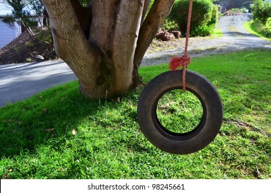 Car tire used as a swing on a tree in the garden. Concept photo of childhood, nostalgia, memory , past, life.Concept photo of childhood, nostalgia, memory , past, life, retro, vintage, home sweet home