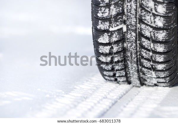 Car tire in\
winter on the road covered with\
snow