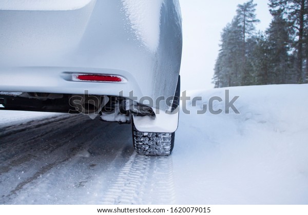 Car tires on winter road covered with snow. Car on\
a snow covered road.