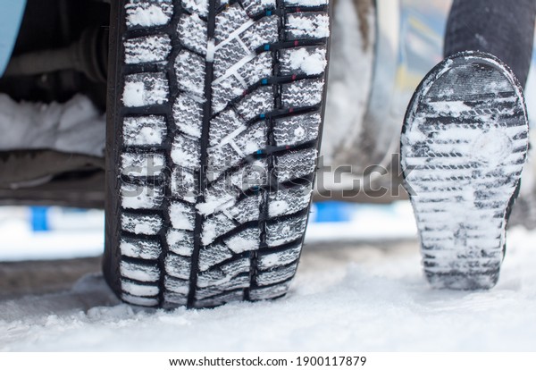 Car tires on\
the winter road are covered with snow. A car on a snow-covered\
alley. A car wheel in the\
snow.