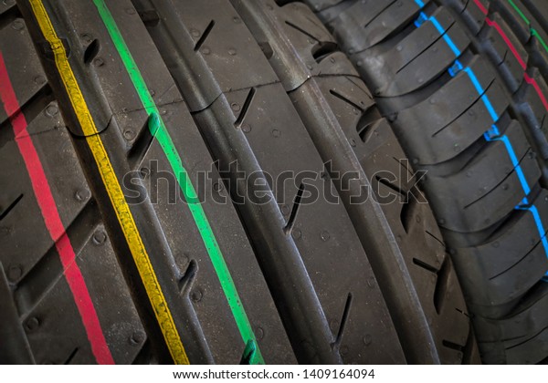 Car tires in a row on a shelf tire.\
Protector of automobile tires. A number of automobile tires. Close\
up view on auto mobile new wheel tire\
surface.