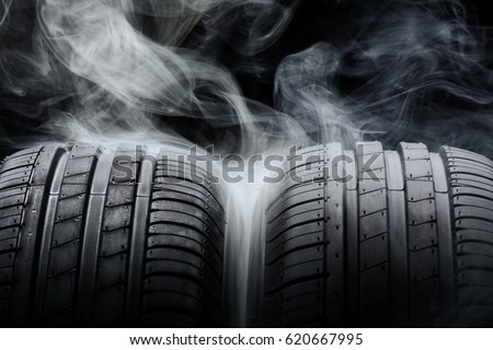 Car tires and smoke on black background