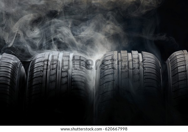 Car tires and smoke\
on black background
