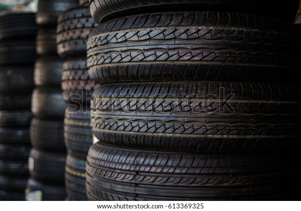 Car tires at warehouse in tire\
store, Tires for sale at a tire store - stacks of old used\
tires