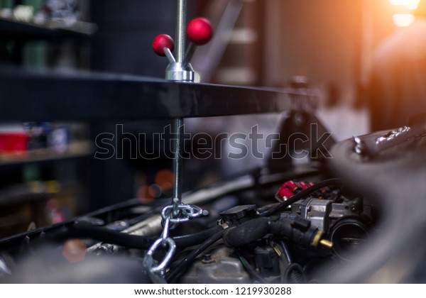 Car tool for engine mount close up with\
beautiful sun on background