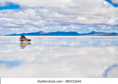 Car Tour On Salar De Uyuni In Bolivia Covered With Water With Clouds Reflection And Soft Focus