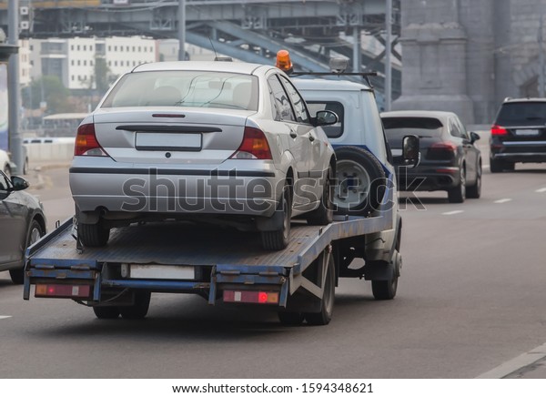 car tow truck
transports a car on a city
street