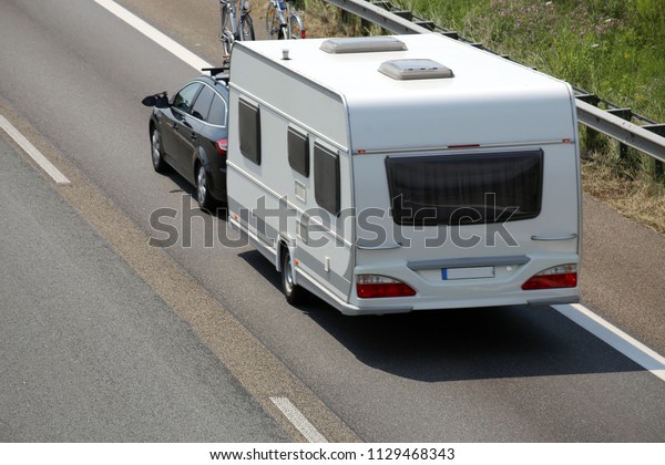 Car towing caravan on\
european motorway