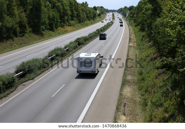 Car towing caravan\
on european motorway\
