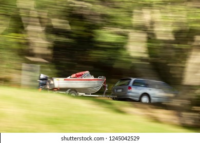 A Car Towing A Trailer Boat With A Panning Motion Technique Blurring The Area Around The Car