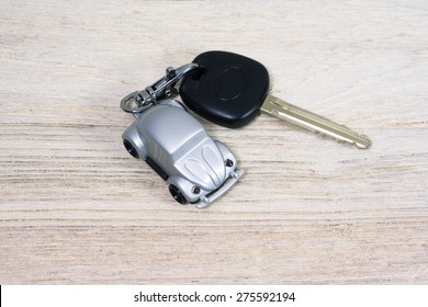 Car toy with car key on white wooden table