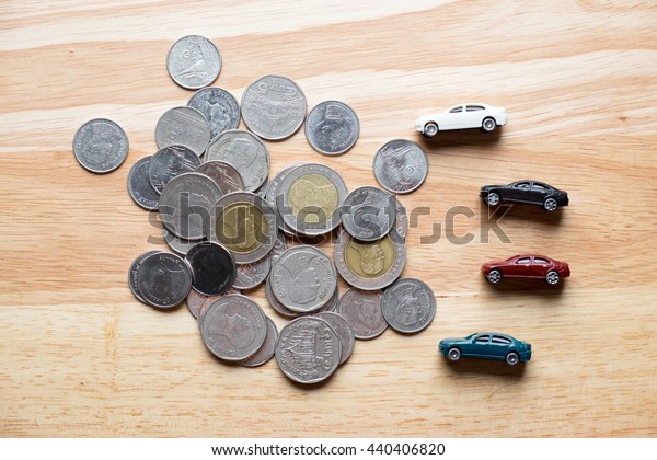 Car toy on coins and wood background. used for
background or material 
design.
