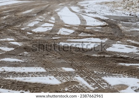 Car tracks on a snowy road. Slippery road, danger, risk of skidding. Traces of winter tire treads.