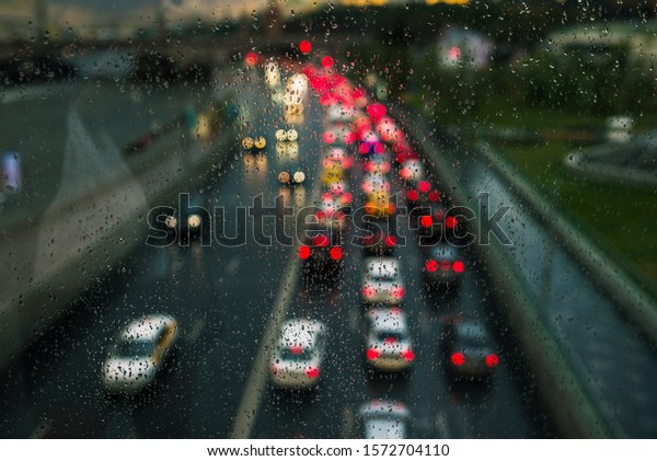 Car traffic in the city in the evening. It\
is raining outside. Blurred headlights from cars. The movement of\
cars on the street. Raindrops on the\
glass.