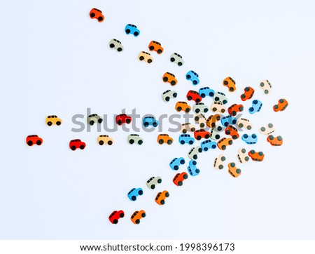 Car traffic jam from small toy cars in the form of an arrow isolated on a white background, top view.