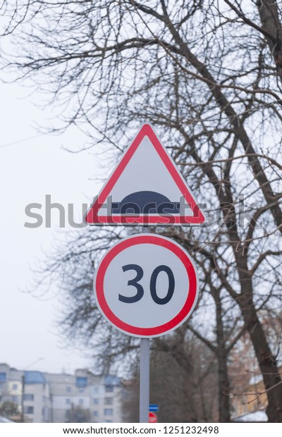 car
traffic signs. Two road signs hang over the
road.