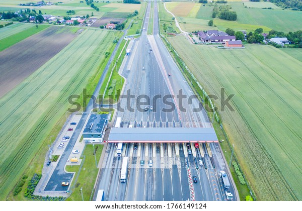 Car traffic transportation on\
multiple lanes highway road and toll collection gate, drone aerial\
top view. Commuter transport, city life concept.A2 Poland\
Lodz
