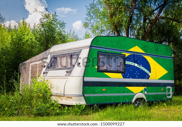 A car trailer, a motor home, painted in the
national flag of  South African Republic stands parked in a
mountainous. The concept of road transport, trade, export and
import between countries.