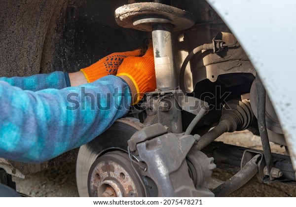 Car transmission and chassis repair. Auto\
mechanic hands fixing the car\
defects