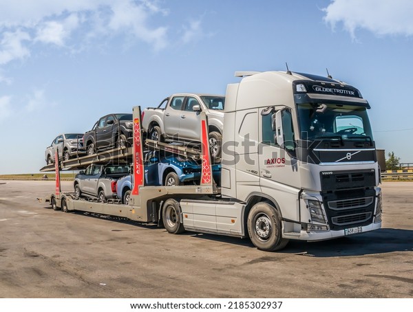 Car\
transporter with cars loaded for transportation on the road on a\
sunny day.Turkestan, Kazakhstan - May 30,\
2022