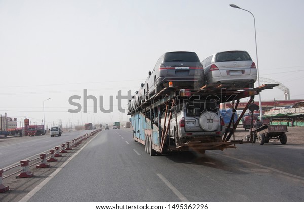 The car\
transporter loads double rows of car on the upper deck. Turpan.\
Xinjiang, Silk Road, OBOR, China. 9/22/11. \
