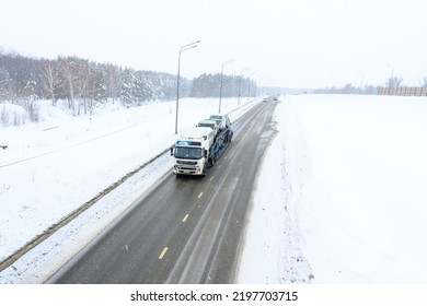 A Car Transporter Trailer, Car Carrier, Semi Truck, Tractor Unit. Cargo Transportation In Harsh Winter Conditions On Slippery, Icy And Snowy Roads. 