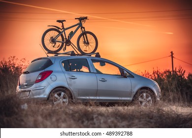 Car is transporting bicycle on the roof.