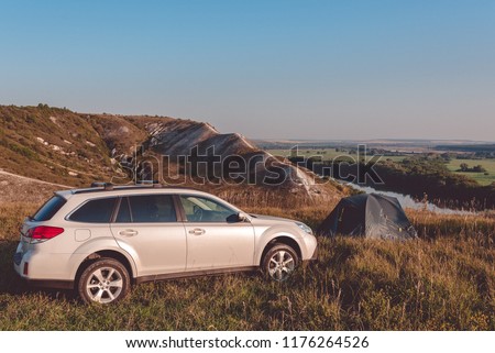 Car travel. Car camping. Car trip. Road trip. Travel concept: SUV and camping tent on top of the mountain Stock photo © 