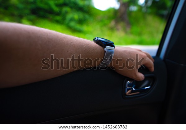 car travel concept man hand on car cart\
at backseats with watch on wrist copy\
space