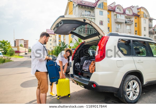 car travel concept. opened trunk with
luggage inside woman with man near it. road
trip