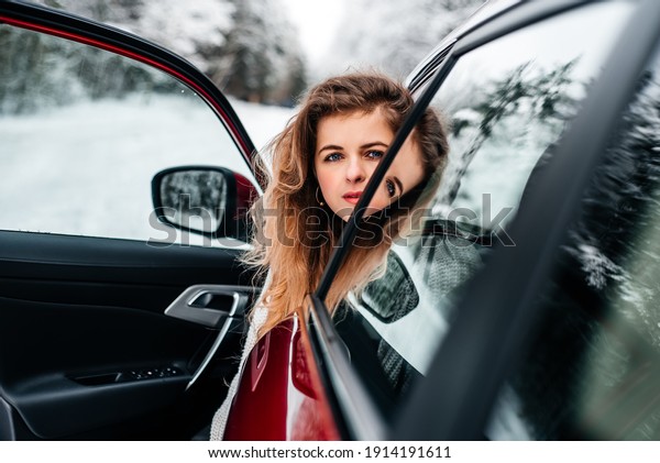 Car travel. A\
girl in a red car, winter\
travel.