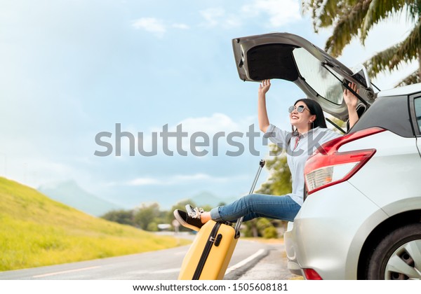 Car travel of woman journey with suitcase open hatchback\
car at mountain road and street in summer vacation road trip on\
holidays to destination, Traveler transportation vehicle people\
lifestyle 