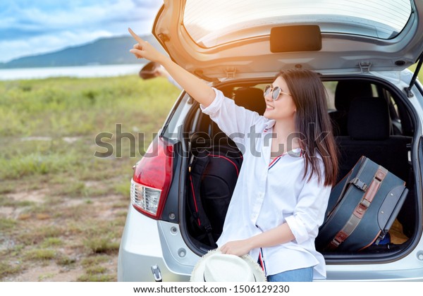 Car travel of woman journey with suitcase open\
hatchback car at lake river mountain in summer vacation road trip\
on holidays to destination, Traveler transportation vehicle people\
lifestyle