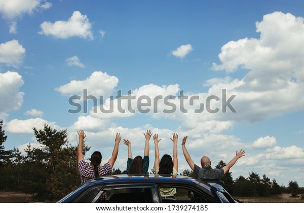 Car traveling. Group of friends\
enjoying vacation together. Road trip, sightseeing,\
friendship