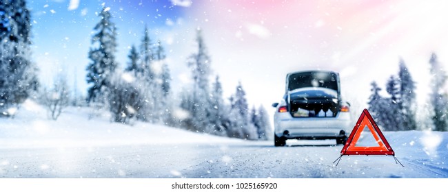 Car triangle on winter road. Problem with vehicle on snowy road. Broken cars concept. Panorama of snowy winter road.