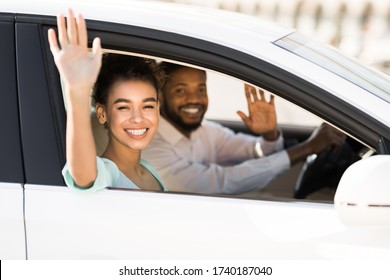 Car Trip. Happy African American Couple Waving Good Bye Sitting In Auto During Ride. Selective Focus