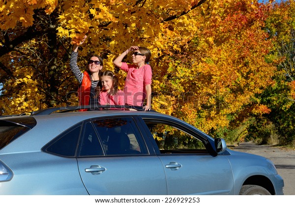 Car trip on autumn\
family vacation, happy mother and kids travel and have fun, car\
insurance concept 