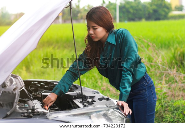 Car\
trouble, asian women worry and stress a trouble with car engine\
crash overheat, women are stressed with broken car and the smoke\
out of the hood,about broken car. About\
insurance.