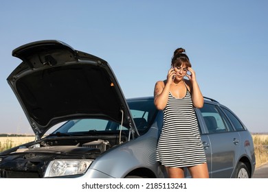 Car Trouble. Woman Worried About Car Troubles On The Road Talking On Smartphone With Roadside Assistance. Girl Standing In Front Of Broken Car Holding Her Head. Desperate Young Woman  Car Trouble