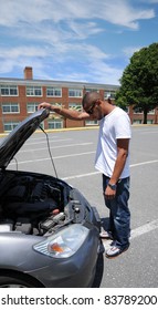 Car Trouble Young Man Hand On Raised Automobile Hood In Parking Lot Looking At Engine