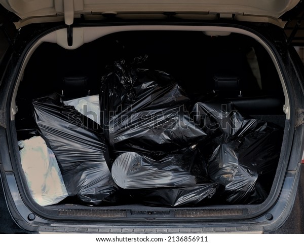 Car trunk full of garbage bags ready to take\
to the dump. Senior downsizing\
