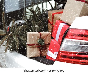 Car With Trunk Full Of Gift Boxes, Presents And Fir Tree For Christmas. Car, Presents, Craft Box, Snow, Holidays. Street Outdoor.