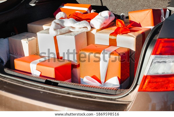 Car with\
trunk full of many gift boxes and presents for Christmas. Presents,\
craft box, holidays. Street\
outdoor.