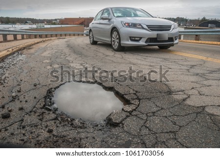Car trying to avoid a big pothole